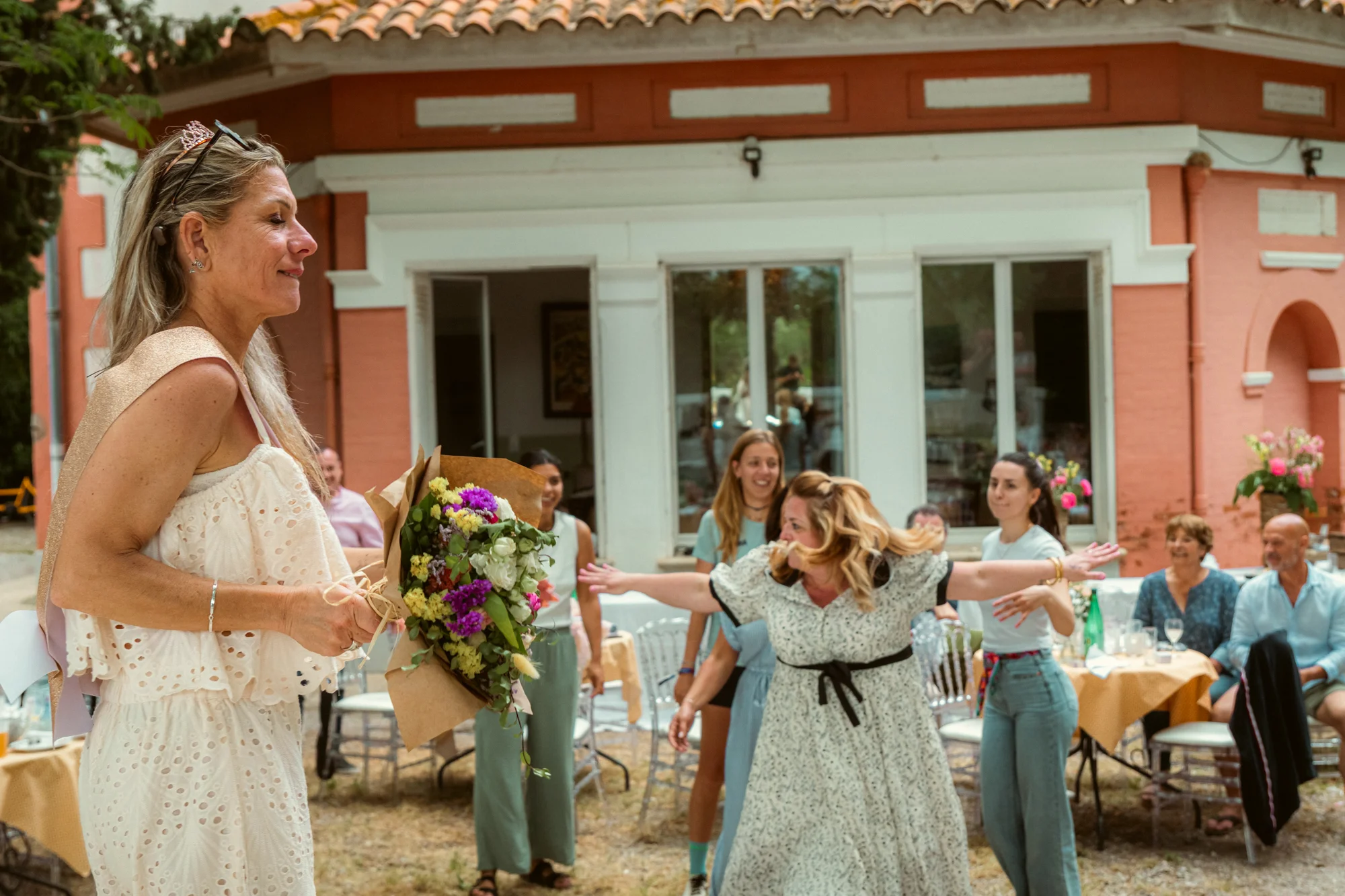 Lancer du bouquet de mariée, invitées tendant les bras, réception en plein air