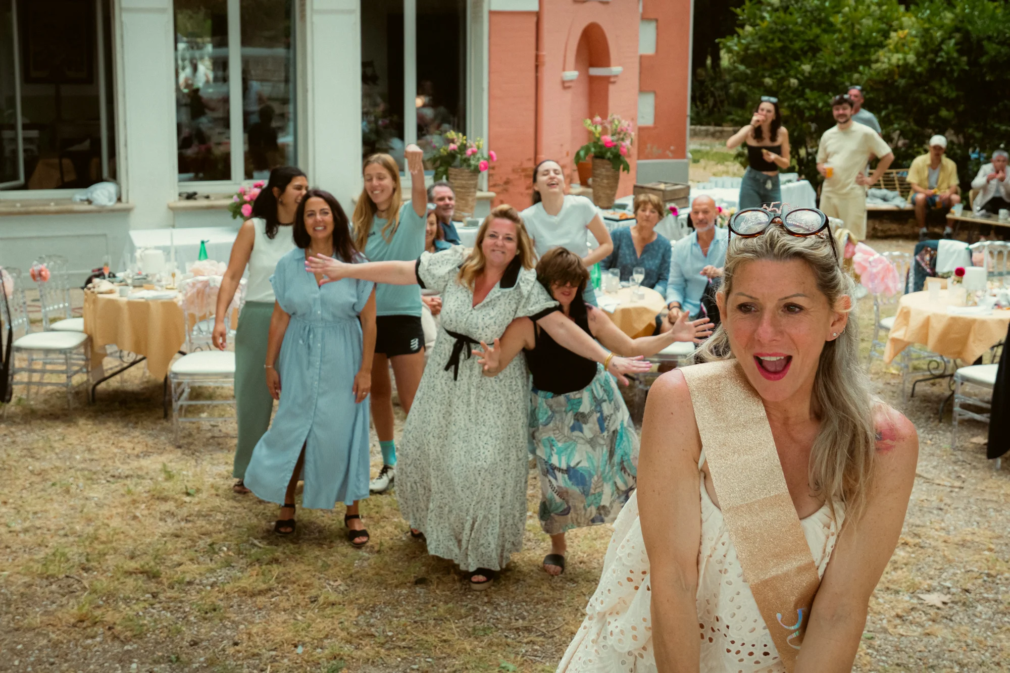 Lancer du bouquet de mariée française, invitées tendant les bras, réception en plein air
